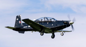 A Royal New Zealand Air Force T-6C Texan II aircraft flying with two people in the aircraft