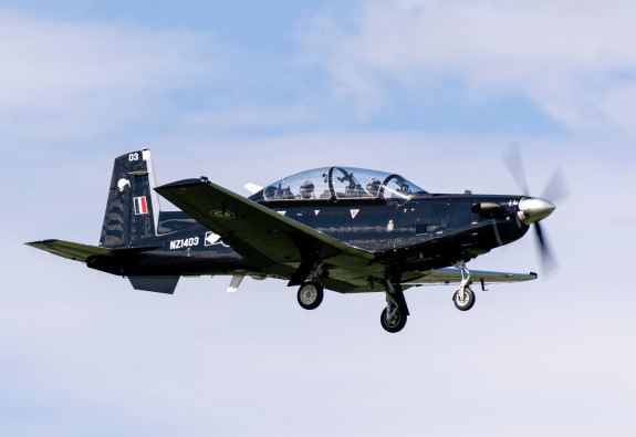 A Royal New Zealand Air Force T-6C Texan II aircraft flying with two people in the aircraft