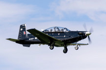 A Royal New Zealand Air Force T-6C Texan II aircraft flying with two people in the aircraft