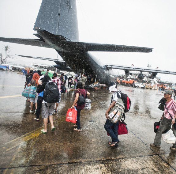 Typhoon Haiyan survivors walk toward the ramp of a RNZAF C-130H(NZ) Hercules in Tacloban, Philippines