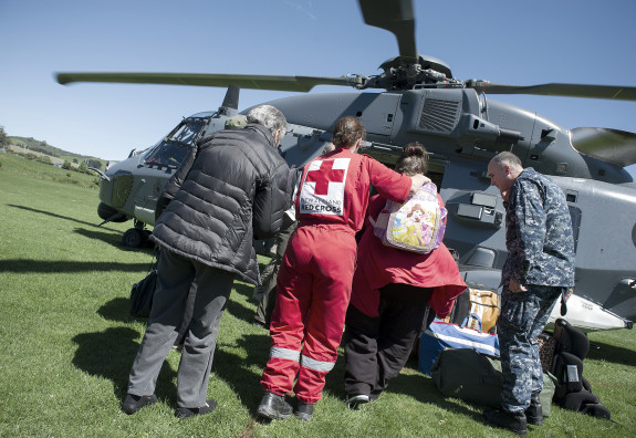 People and first aid workers board a Royal New Zealand Air Force NH90 helicopter 