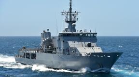 Royal New Zealand Navy's HMNZS Otago sailing on the ocean on a nice day with blue sky. 