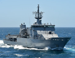 Royal New Zealand Navy's HMNZS Otago sailing on the ocean on a nice day with blue sky. 