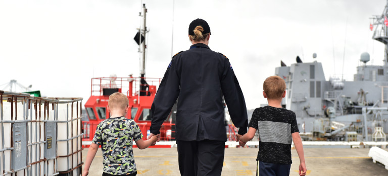 A Royal New Zealand Navy sailor with some of their family.