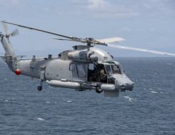 A Royal New Zealand SH-2G(I) Seasprite Helicopter flies over the ocean