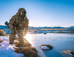 New Zealand Army sniper moves around a water area in the snow in the Tekapo Military Training Area