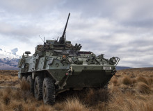 A New Zealand Army Light Armoured Vehicle (NZLAV) on the tussock grass in the Waiouru Military Training Area. In the background you can see a snow-capped Mt Ruapehu