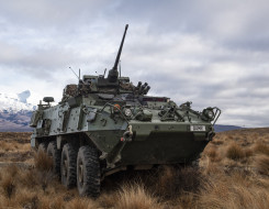 A New Zealand Army Light Armoured Vehicle (NZLAV) on the tussock grass in the Waiouru Military Training Area. In the background you can see a snow-capped Mt Ruapehu