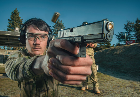 A New Zealand Army soldier fires a Glock G17 Gen 4 with another soldier standing behind them. 