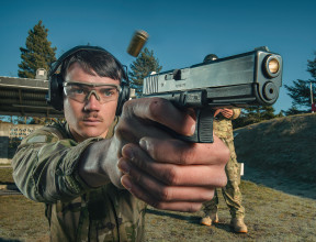 A New Zealand Army soldier fires a Glock G17 Gen 4 with another soldier standing behind them.