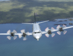 P-3K2 Orion flies over the ocean with land behind it. 