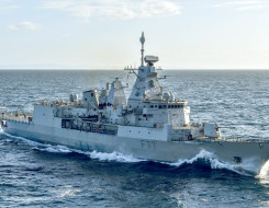 HMNZS Te Kaha sails on the ocean on a sunny day