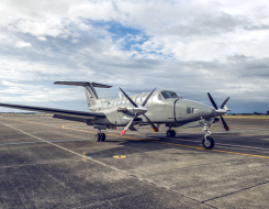 A King Air 350 aircraft sits on the flightline. The sky is cloudy with partial blue sky.