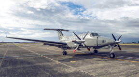 A King Air 350 aircraft sits on the flightline. The sky is cloudy with partial blue sky.