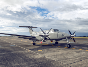 A King Air 350 aircraft sits on the flightline. The sky is cloudy with partial blue sky.