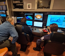 Crew of HMNZS Manawanui review underwater footage of a plane staged on the seabed during the recovery exercise.