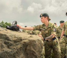 Soldiers in full uniform line up to touch the anchor stone.