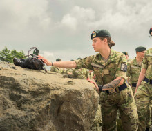 Soldiers in full uniform line up to touch the anchor stone.