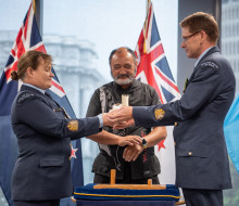 The outgoing Warrant Officer of the Air Force, W/O Toni Tate, hands the Conch, the traditional symbol of the role, to successor W/O Kerry Williams at a ceremony in Defence House this morning. Air Force Tūrangawaewae manager Doug Wallace looks on.