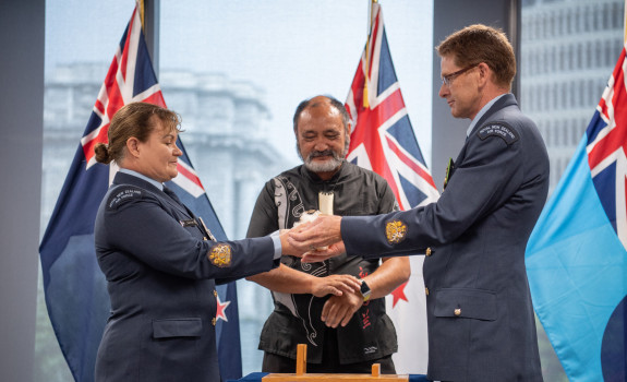 The outgoing Warrant Officer of the Air Force, W/O Toni Tate, hands the Conch, the traditional symbol of the role, to successor W/O Kerry Williams at a ceremony in Defence House this morning. Air Force Tūrangawaewae manager Doug Wallace looks on.