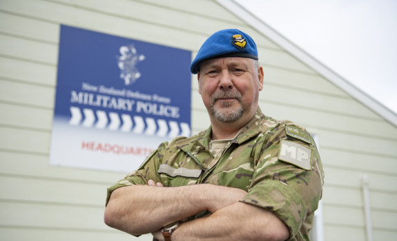 Wing Commander Peel looks at the camera with arms folded.