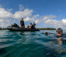 Divers return to the surface after a dive inspecting an unexploded ordinance in Tuvalu.