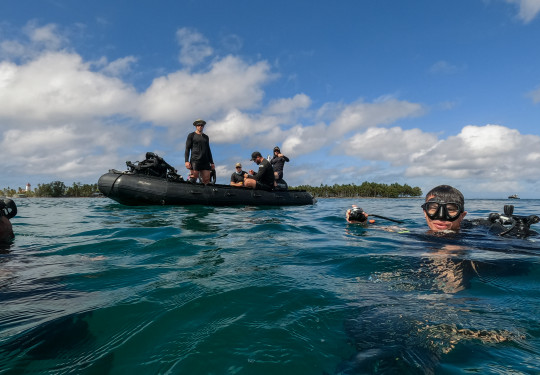 Divers return to the surface after a dive inspecting an unexploded ordinance in Tuvalu.