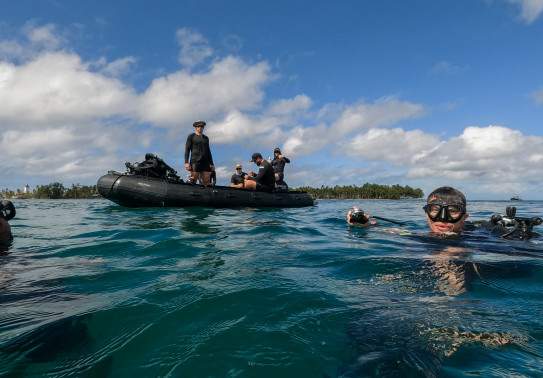 Divers return to the surface after a dive inspecting an unexploded ordinance in Tuvalu.