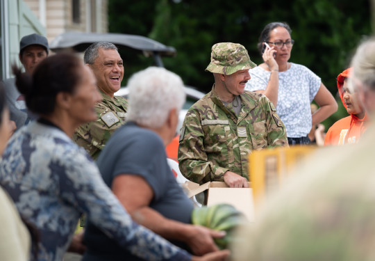 Soliders smile while talking to residents of Moteo while they help distribute food to the stranded locals. 