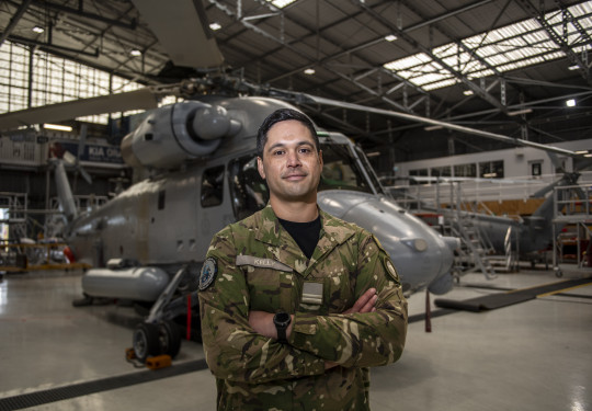 oyal New Zealand Air Force (RNZAF) engineering officer Flight Lieutenant Donté Kelly standing in front of a Seasprite.