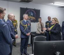 Senior aviators talk to the Minister for Space in a control room.