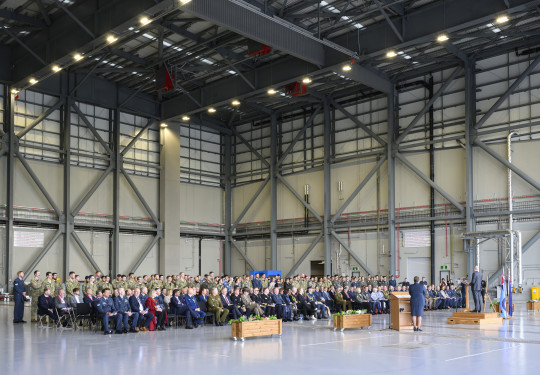 A crowd of people seated in a large aircraft hangar.