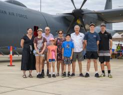 A nine-person family photo in front of a Royal Australian Air Force aircraft.
