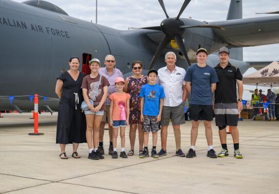 A nine-person family photo in front of a Royal Australian Air Force aircraft.