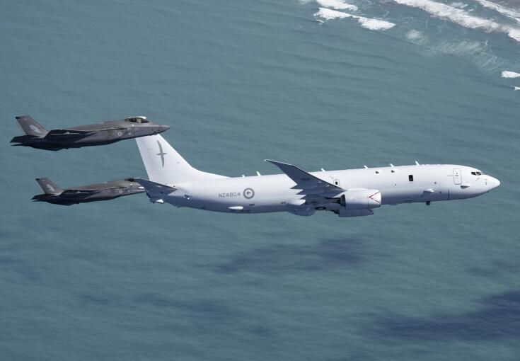 Two RAAF F-35As conducting intercept training with an RNZAF P-8A Poseidon - the aircraft are flying over water. 