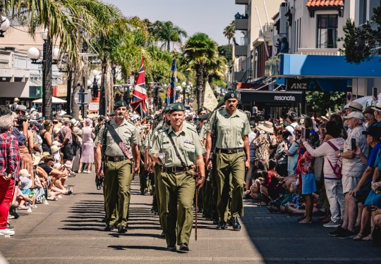 Army personnel march through the city of Napier with swords drawn, bayonets fixed, music playing and Colours flying.