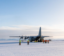 A Royal New Zealand Air Force C-130 Hercules in Antarctica sitting on the ice.