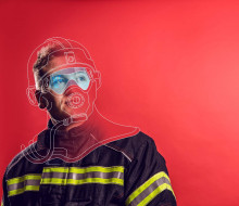 RNZAF Firefighter looking away from camera. The image is a mix of photo and graphic. Red background and illustrations drawn over his head