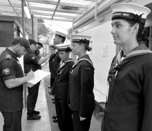 Navy recruits stand in a line as they have their uniform inspected during the Basic Common Training course.