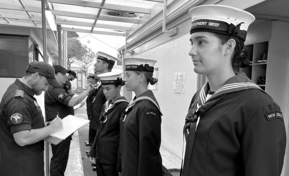 Navy recruits stand in a line as they have their uniform inspected during the Basic Common Training course.