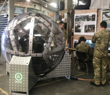 NZ Army soldiers gather around the zorb-like NOVA driving simulation technology