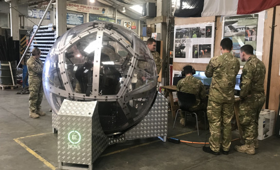 NZ Army soldiers gather around the zorb-like NOVA driving simulation technology