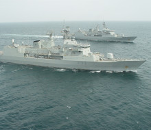 HMNZS Te Mana (background) joins HMNZS Te Kaha (foreground) at the end of the latter’s deployment.
