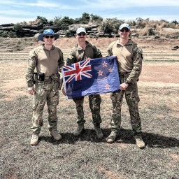Three soldiers holding New Zealand flag