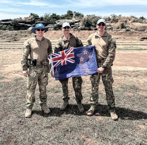 Three soldiers holding New Zealand flag