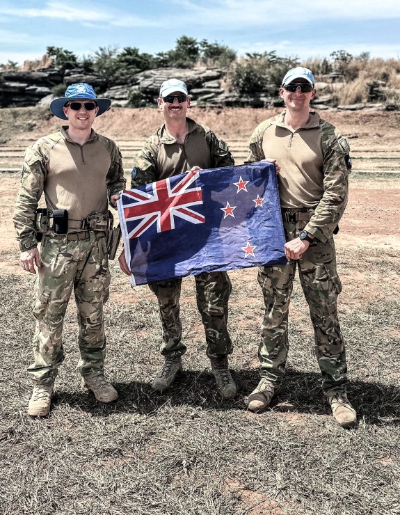 Three soldiers holding New Zealand flag