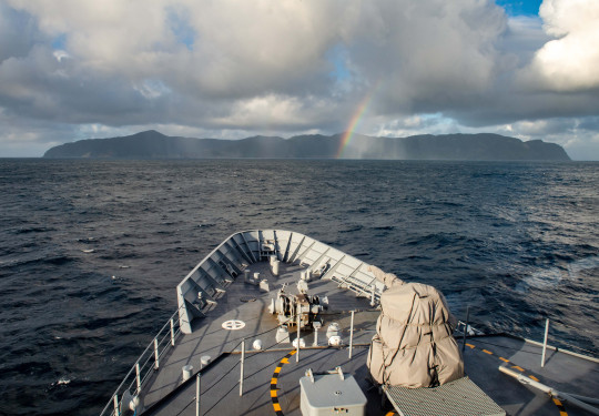 HMNZS Wellington with Raoul Island in the background, taken in August this year. The photo is taken from the bridge of the ship. Towards the island you can see a small rainbow. 