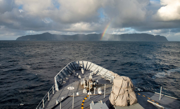 HMNZS Wellington with Raoul Island in the background, taken in August this year. The photo is taken from the bridge of the ship. Towards the island you can see a small rainbow.