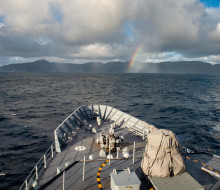 HMNZS Wellington with Raoul Island in the background, taken in August this year. The photo is taken from the bridge of the ship. Towards the island you can see a small rainbow.