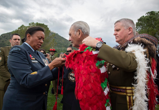 Chief of New Zealand Army Major General John Boswell (right) places our Ngā Tapuwae kahu huruhuru on the last surviving member of B Company, Robert Gillies 2019. A member of the RNZAF assists in the tie on a cloudy day. 